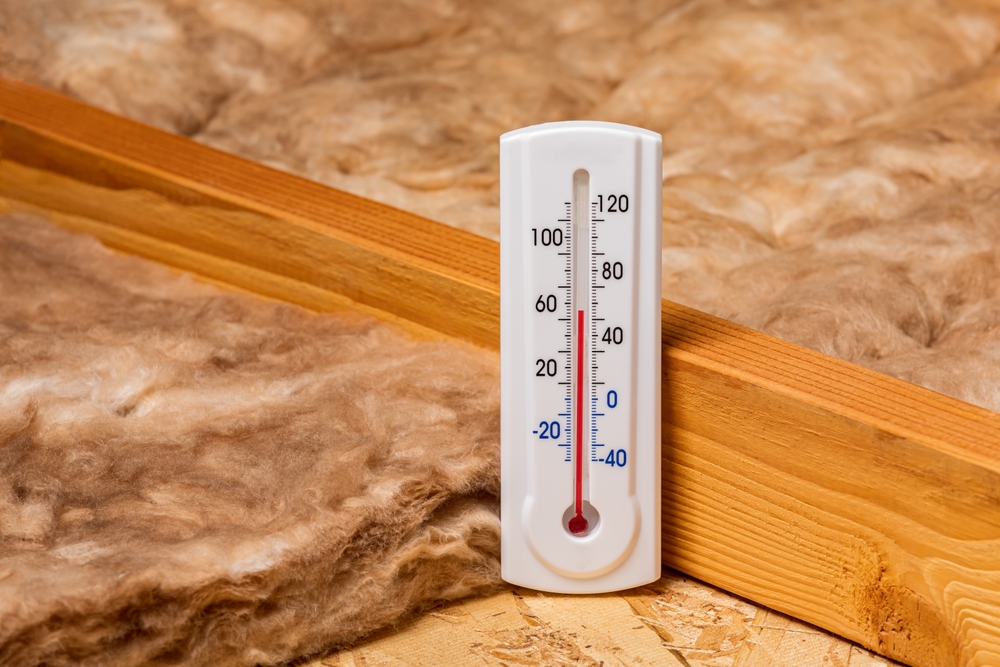 Fiberglass,insulation,in,attic,of,house,with,thermometer.,home,energy