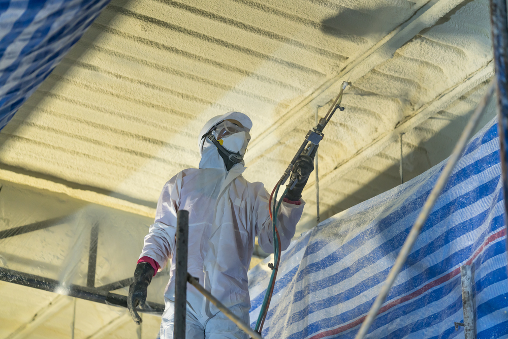 Technician,spraying,foam,insulation,using,plural,component,gun,for,polyurethane